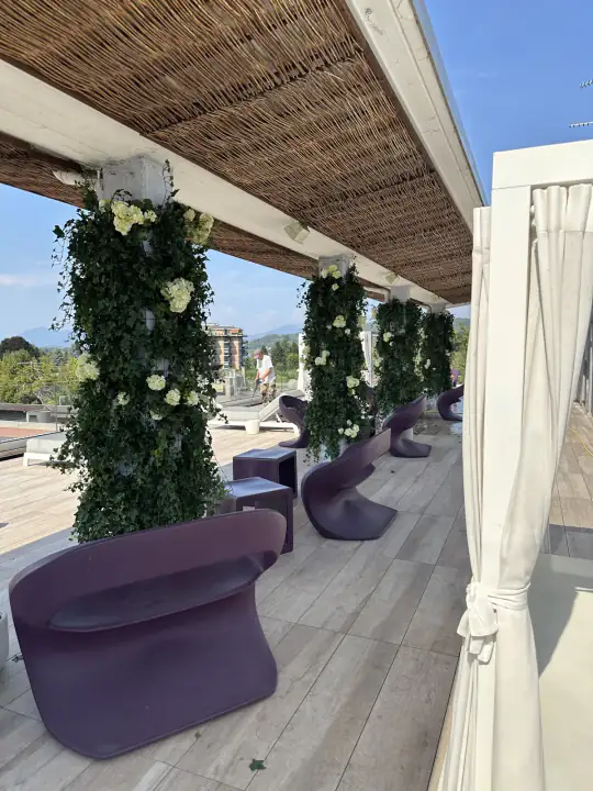 Zona lounge della terrazza con colonne rivestite di edera artificiale